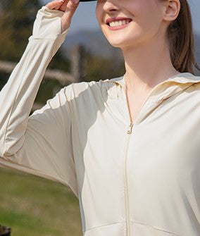 Woman in a yellow sun protection jacket pulling the hood over her head.