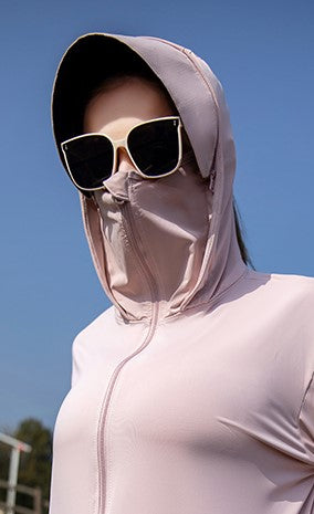 Woman wearing sunglasses and a pink sun protection jacket with a hood.