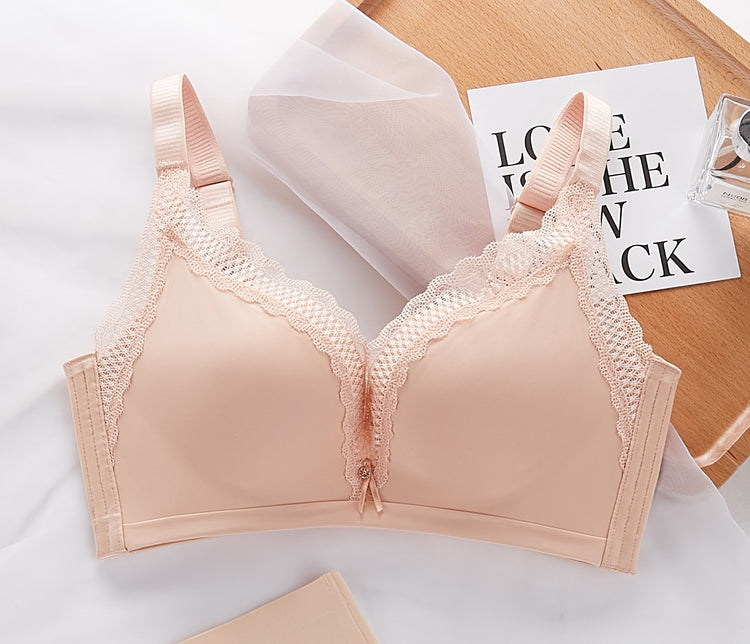 A beige lace push-up bra displayed on a flat surface, featuring lace-trimmed cups and adjustable straps.