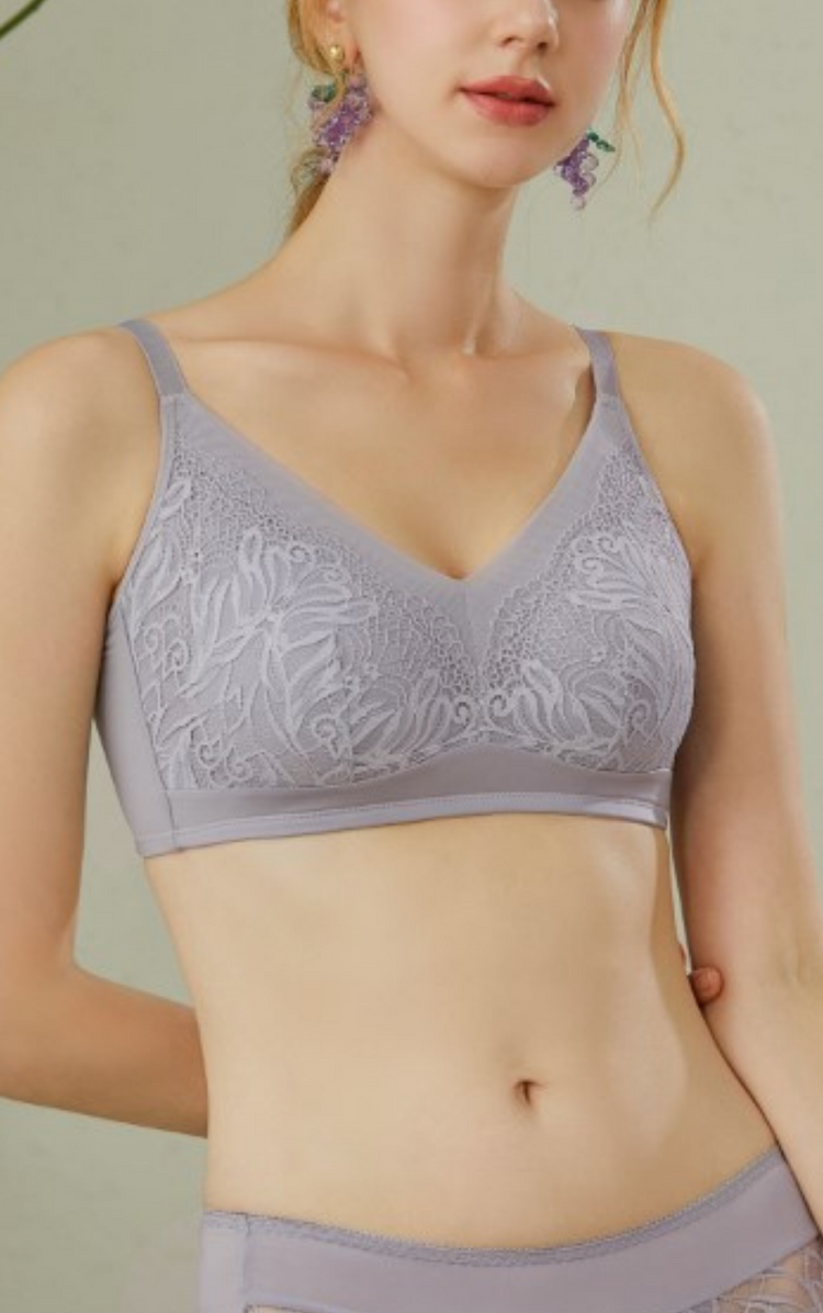 Front view of a woman wearing a grey lace wireless minimizer bra, showing the comfortable fit and elegant lace details.